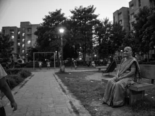 to the right: a grandmother on a bench, watching the playground
