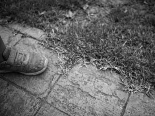below the wrist: paving stones and a sneaker